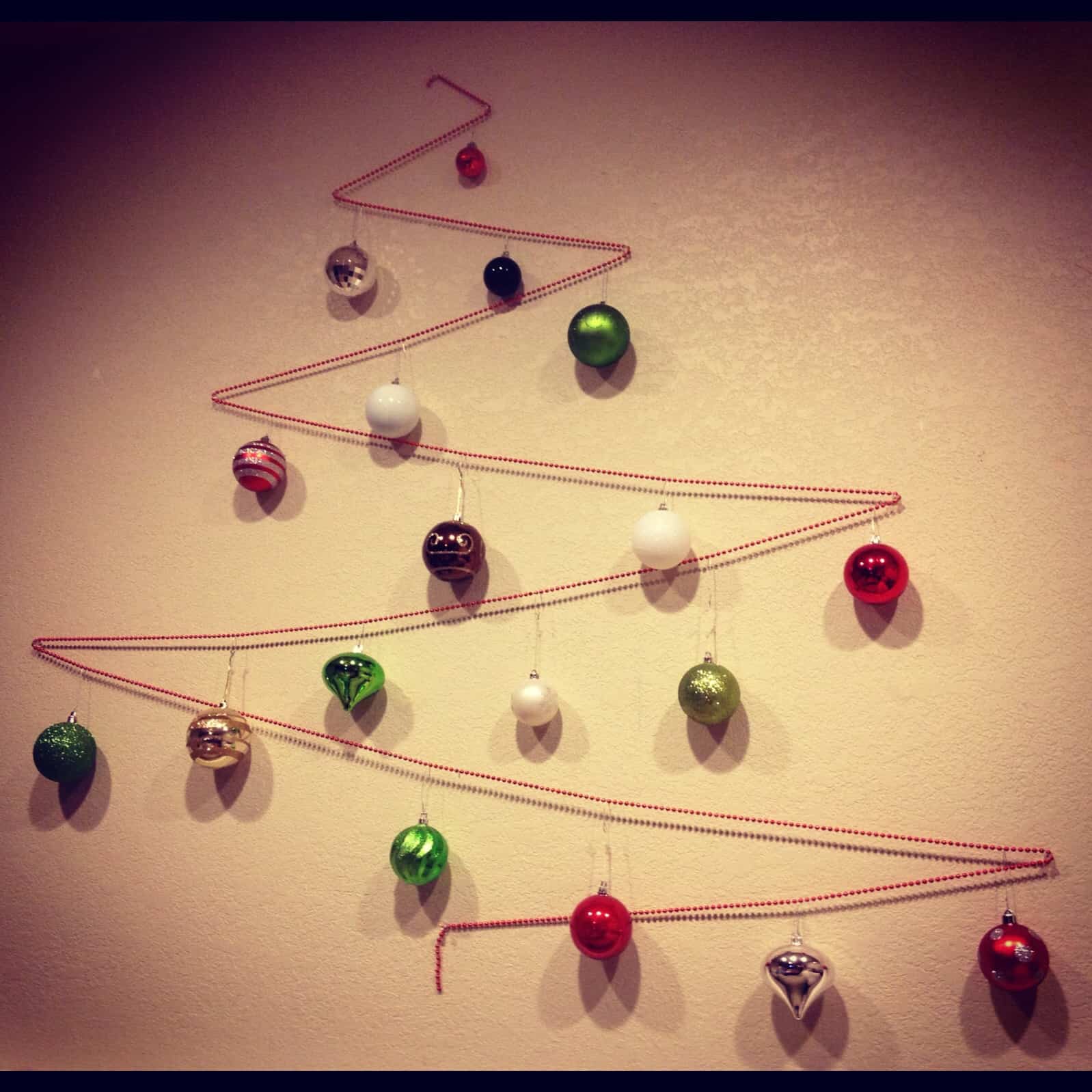 árbol de navidad hecho en la pared con bolas